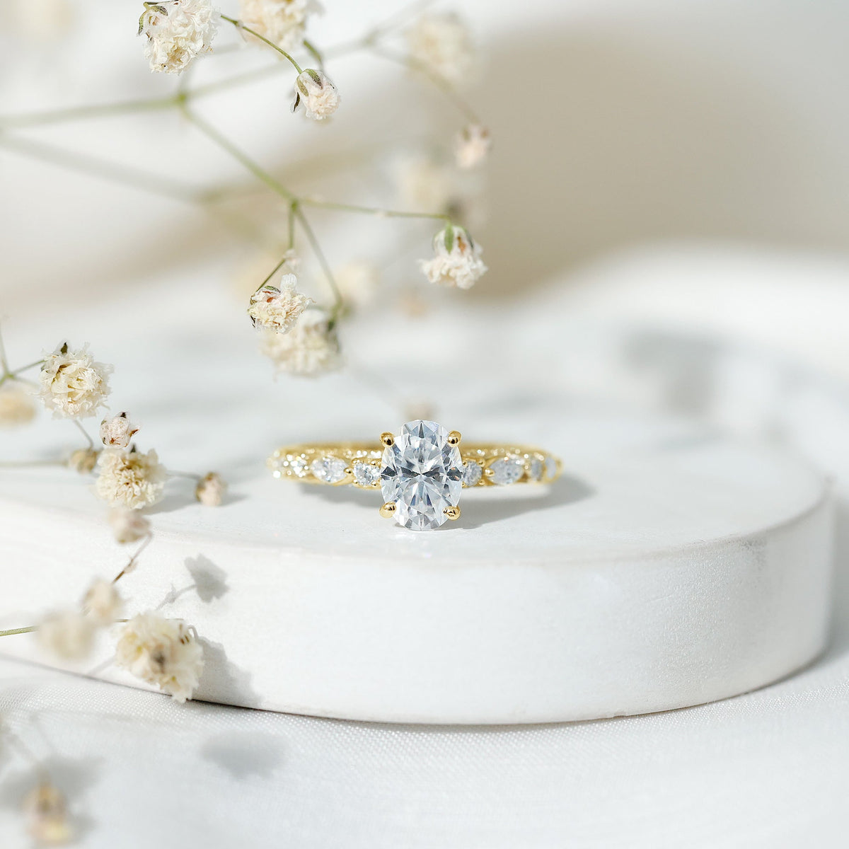 Oval moissanite solitaire engagement ring in claw setting with a rose gold band, showcasing sparkling gemstone and elegant design.