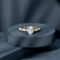 Oval moissanite solitaire engagement ring in claw setting with a silver band, featuring a sparkling central gemstone.