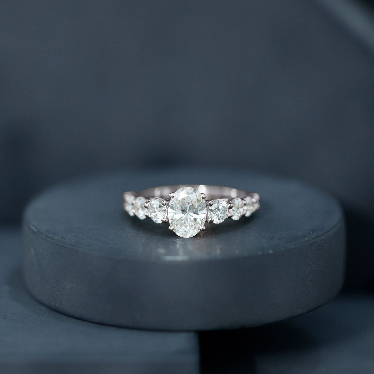 Oval cut moissanite side stones engagement ring in rose gold with intricate detailing by Rosec Jewels.