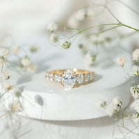 Oval cut moissanite side stone engagement ring with a 1.2 carat center, featuring sparkling stones and a polished band from Rosec Jewels.