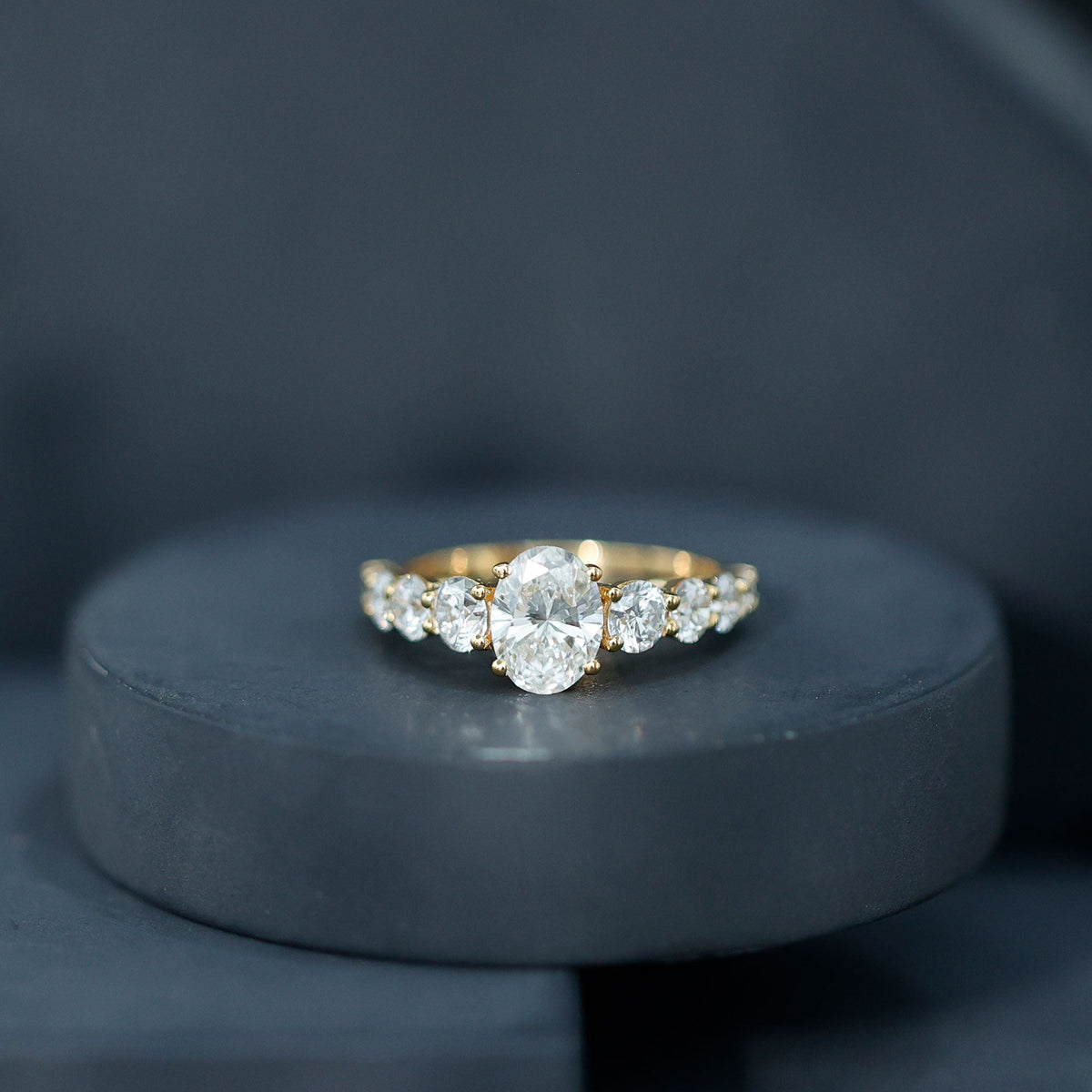 Oval cut 1.2 carat moissanite side stone engagement ring from Rosec Jewels, showcasing the sparkling central gemstone and elegant band.