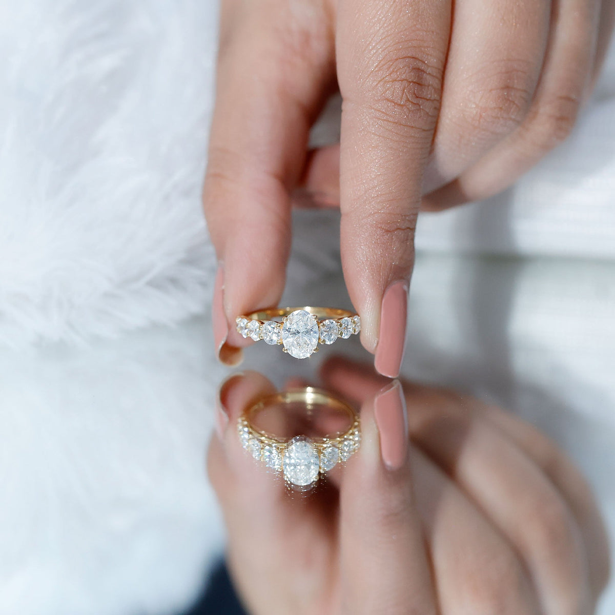 Oval cut 1.2 carat moissanite side stone engagement ring by Rosec Jewels, featuring a sparkling central stone and intricate band design.