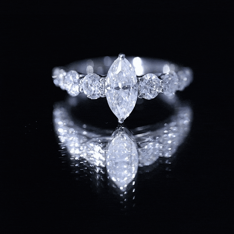 Yellow gold marquise moissanite engagement ring with side stones from Rosec Jewels, showcasing the elegant design and sparkling gemstones.
