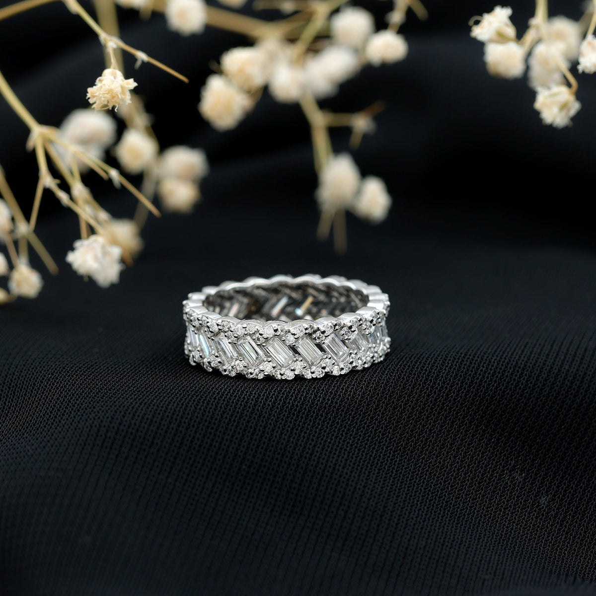 Rosec Jewels moissanite braided wedding band with baguette and round stones, showcasing intricate design and sparkling gemstones.