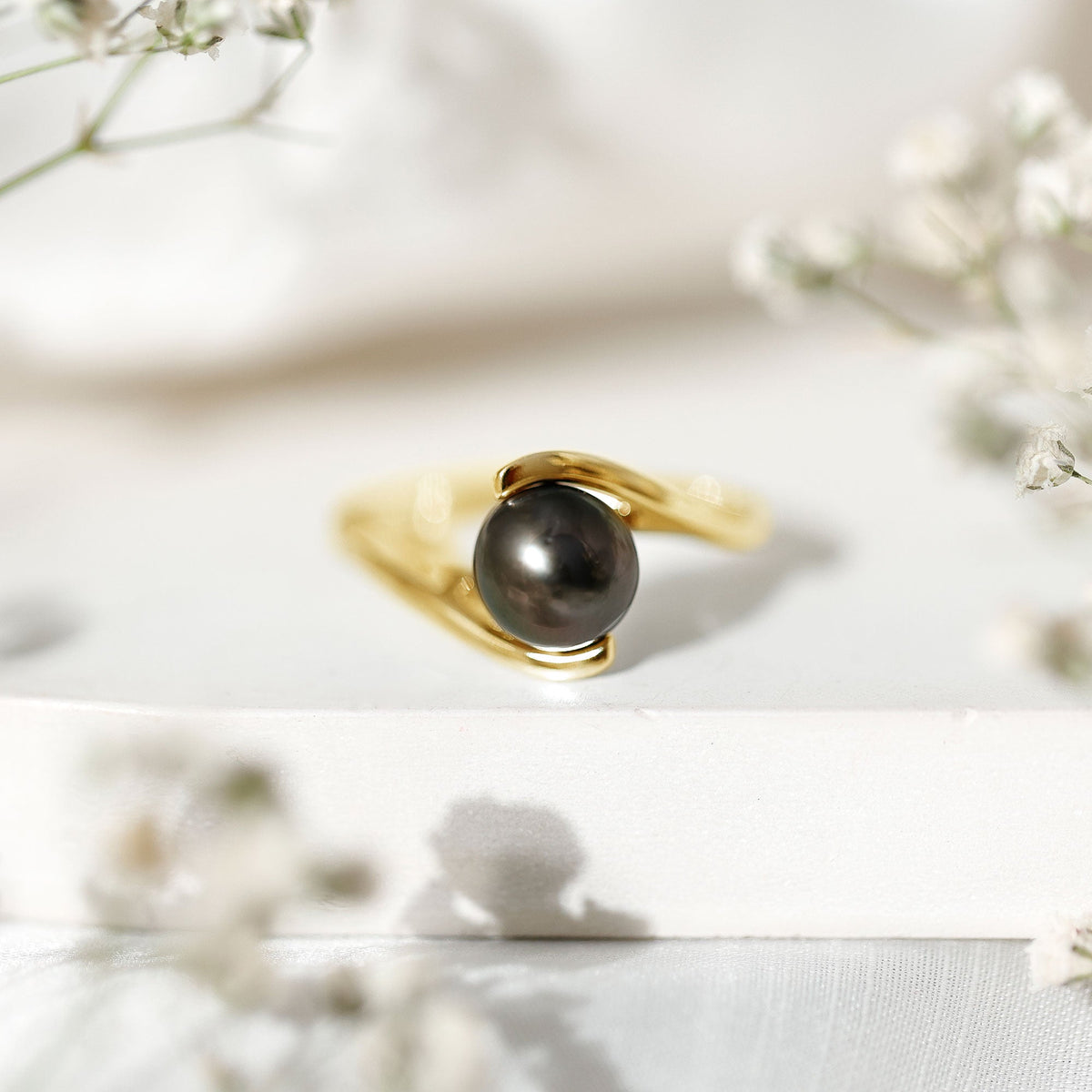 Tahitian black pearl solitaire bypass engagement ring from Rosec Jewels featuring a black pearl set on a sleek silver band.