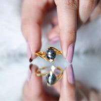 Tahitian black pearl solitaire bypass engagement ring by Rosec Jewels featuring a black pearl set on a sleek silver band.
