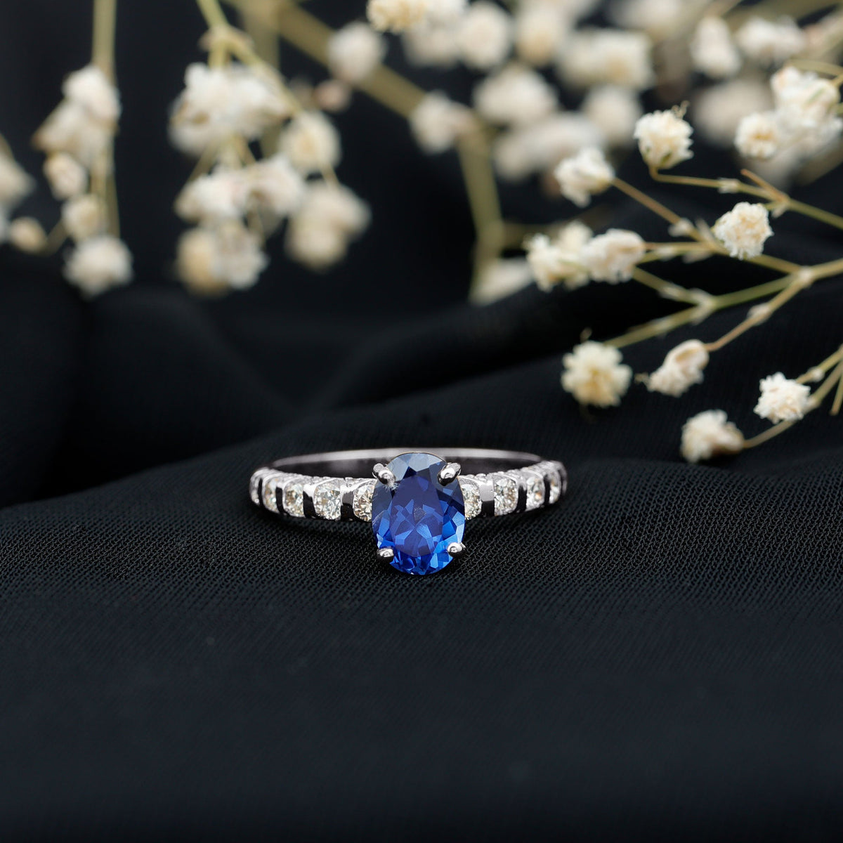 Oval lab-grown blue sapphire engagement ring with diamonds by Rosec Jewels, showcasing a 1.5-carat gemstone and elegant design.