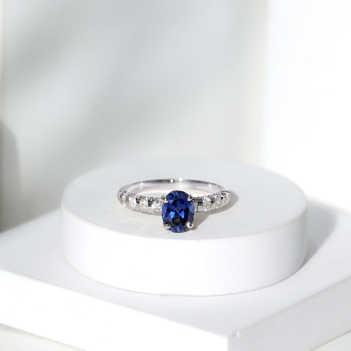 Oval lab-grown blue sapphire engagement ring with diamond accents by Rosec Jewels, showcasing a 1.5-carat center stone and elegant design.