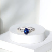 Oval lab-grown blue sapphire engagement ring with diamond accents by Rosec Jewels, showcasing a 1.5-carat center stone and elegant design.