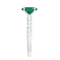 Natural 6x8mm emerald oval engagement ring with diamond side stones, featuring a rose gold band and intricate detailing.