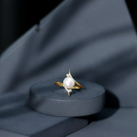 Cultured 7.4 carat freshwater pearl engagement ring with diamond bypass shank by Rosec Jewels, showcasing elegant design.