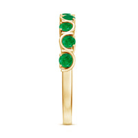 Stackable green emerald half eternity ring by Rosec Jewels featuring a row of vibrant green emeralds set in a sleek gold band.