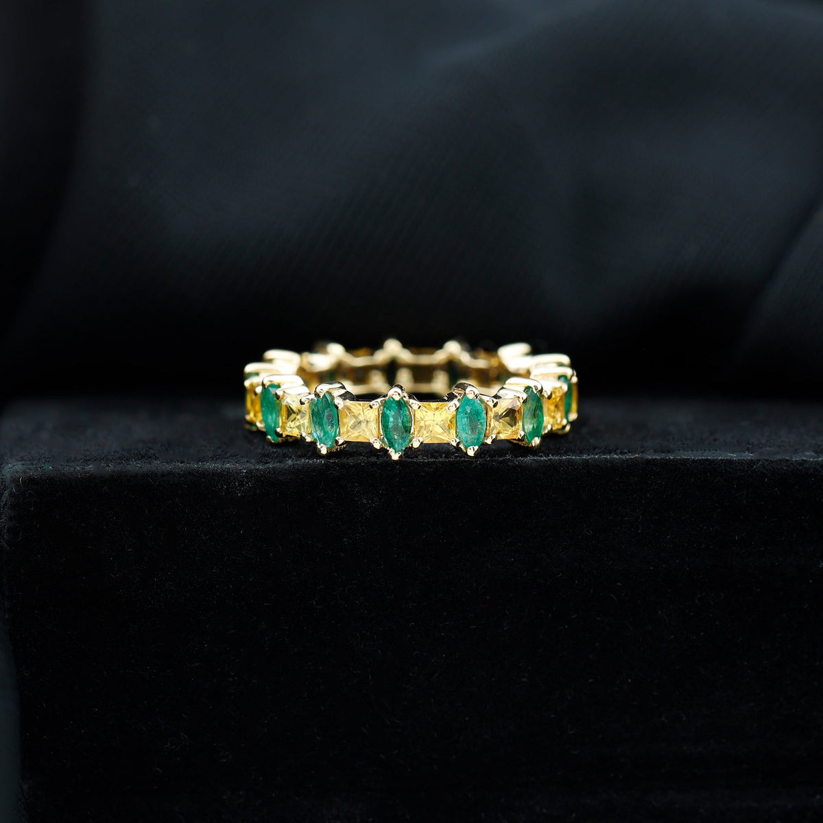 Gold eternity wedding band by Rosec Jewels featuring yellow sapphire and emerald gemstones in a continuous circle design