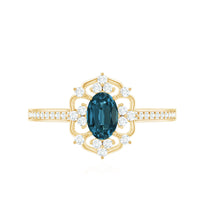 Oval cut London Blue Topaz vintage engagement ring with diamond accents, featuring intricate metalwork and a classic design.