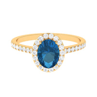 Oval cut London Blue Topaz solitaire ring with diamond halo, set in a elegant jewelry ring by Rosec Jewels.