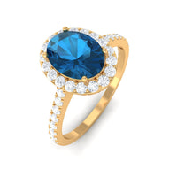 Rosec Jewels 2 CT oval London Blue Topaz solitaire ring with diamond halo, showcasing a stunning blue gemstone and sparkling halo setting.