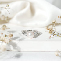 Genuine 7.4 carat freshwater pearl engagement ring with diamond crossover shank by Rosec Jewels, shown on a white background.