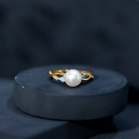 Genuine 7.4 carat freshwater pearl engagement ring with diamond crossover shank by Rosec Jewels, showcasing elegant gold band and intricate design.