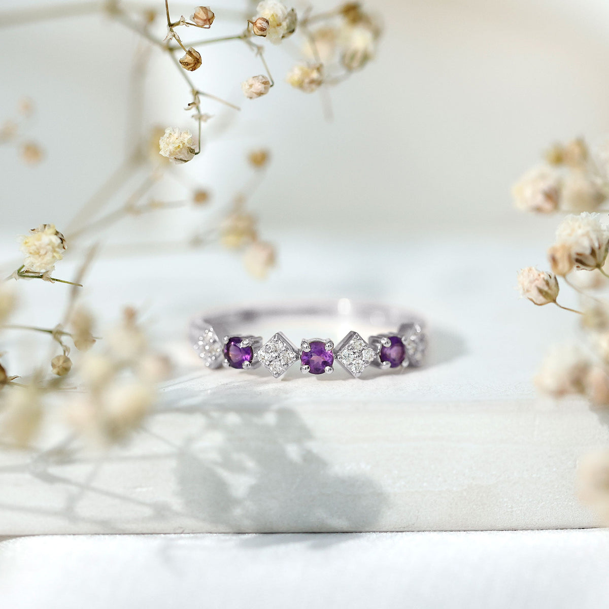 Real amethyst half eternity ring with diamonds for women, showcasing rose gold band and sparkling gemstone accents.