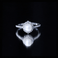 Freshwater pearl and diamond halo engagement ring by Rosec Jewels, featuring a central pearl surrounded by sparkling diamonds.