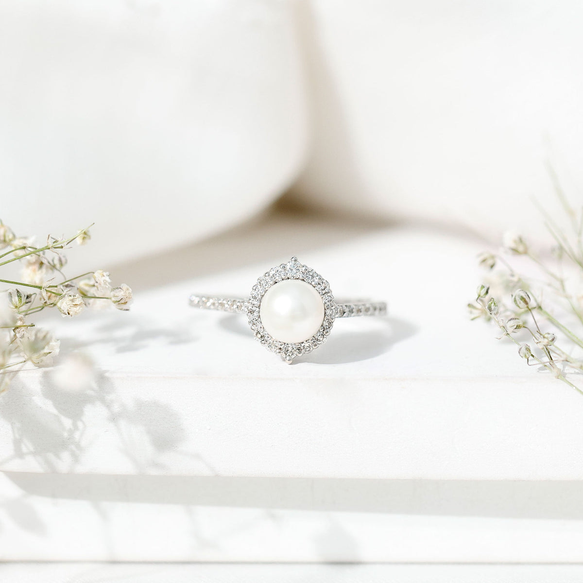 Freshwater pearl and diamond halo engagement ring by Rosec Jewels featuring a central pearl surrounded by sparkling diamonds.