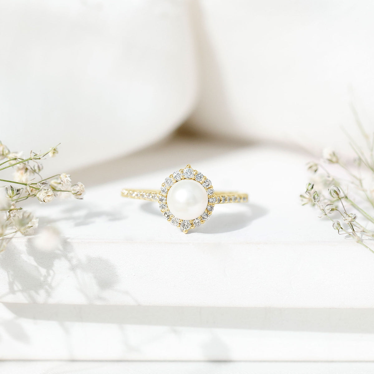 Freshwater pearl and diamond halo engagement ring by Rosec Jewels, featuring a central pearl surrounded by sparkling diamonds.