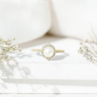 Freshwater pearl and diamond halo engagement ring by Rosec Jewels, featuring a central pearl surrounded by sparkling diamonds.