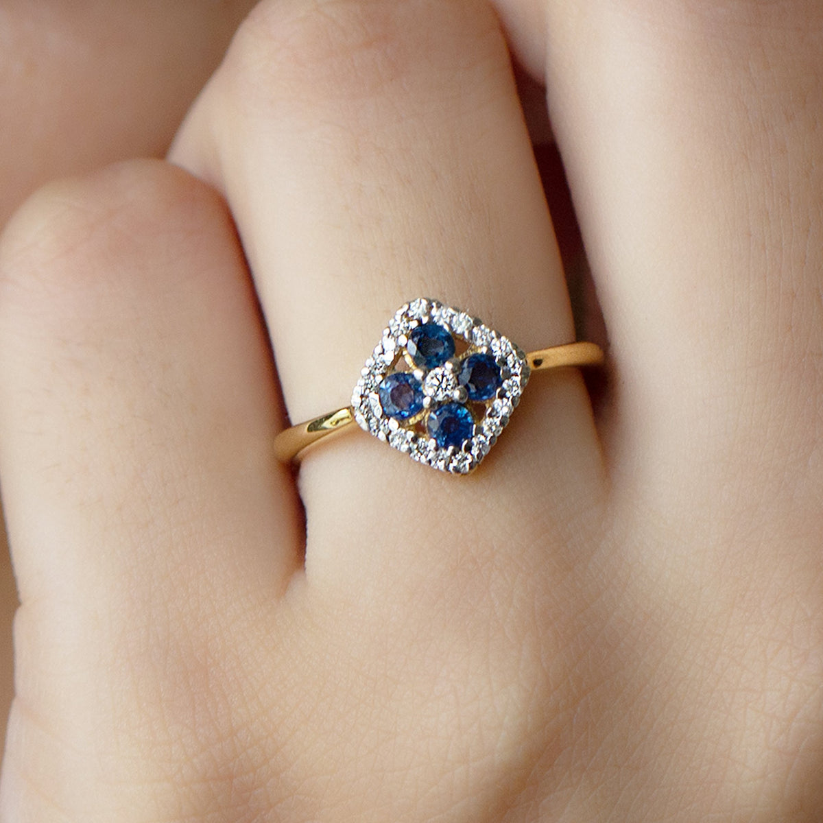 Blue sapphire cluster ring with diamond accents, 1/2 carat total weight, showcasing a elegant design by Rosec Jewels.