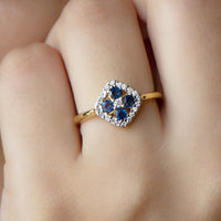 Blue sapphire cluster ring with diamond accents, 1/2 carat total weight, showcasing a elegant design by Rosec Jewels.