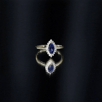 Marquise cut lab-grown blue sapphire and diamond halo engagement ring by Rosec Jewels, showcasing a sparkling blue gemstone and intricate setting.