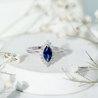 Marquise cut lab-grown blue sapphire engagement ring with diamond halo and rose gold band by Rosec Jewels