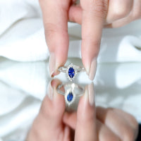 Marquise cut lab-grown blue sapphire engagement ring with diamond halo, showcasing elegant jewelry design by Rosec Jewels