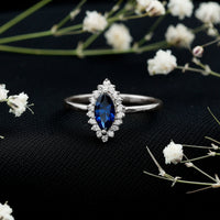 Marquise cut lab-grown blue sapphire engagement ring with diamond halo, featuring Rosec Jewels' elegant ring design.