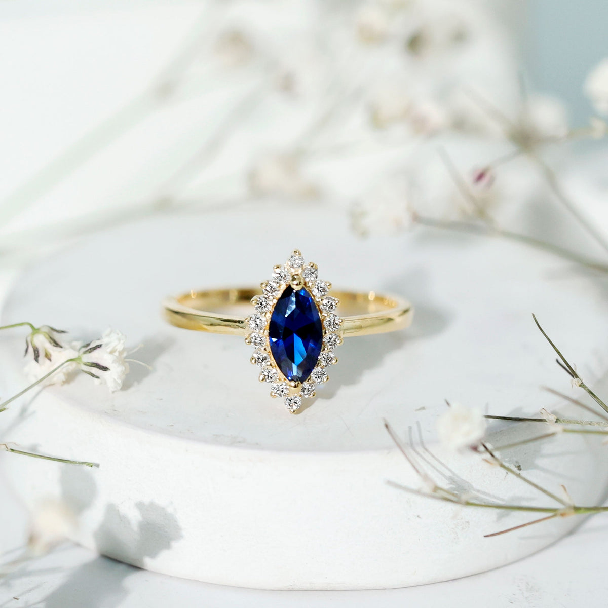Marquise cut lab-grown blue sapphire and diamond halo engagement ring from Rosec Jewels, showcasing sparkling gemstones and intricate band design.