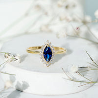 Marquise cut lab-grown blue sapphire and diamond halo engagement ring from Rosec Jewels, showcasing sparkling gemstones and intricate band design.
