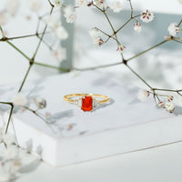 Emerald cut fire opal engagement ring with diamonds from Rosec Jewels, showcasing a vibrant orange gemstone and sparkling accents.