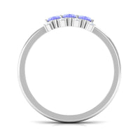 Oval cut tanzanite three-stone ring with diamond accents, crafted by Rosec Jewels, featuring a elegant and sparkling design.