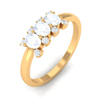 Oval cut moonstone three-stone ring with diamond accents by Rosec Jewels, showcasing the elegant jewelry design.