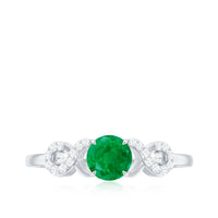 Elegant real emerald diamond engagement ring with a criss-cross shank from Rosec Jewels, showcasing sparkling emerald and diamond accents.
