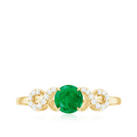 Real emerald and diamond promise engagement ring with a criss-cross shank from Rosec Jewels, featuring a central emerald gemstone.