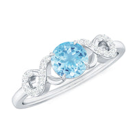 Round aquamarine and diamond infinity engagement ring by Rosec Jewels featuring a polished band with shimmering gemstones.