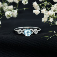 Round aquamarine and diamond infinity engagement ring by Rosec Jewels featuring a sleek, elegant design with sparkling gemstones.