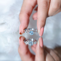 Round aquamarine and diamond infinity engagement ring by Rosec Jewels, featuring a sleek silver band with sparkling stones.