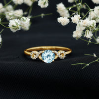 Round aquamarine and diamond infinity engagement ring by Rosec Jewels featuring a delicate band and sparkling stones.