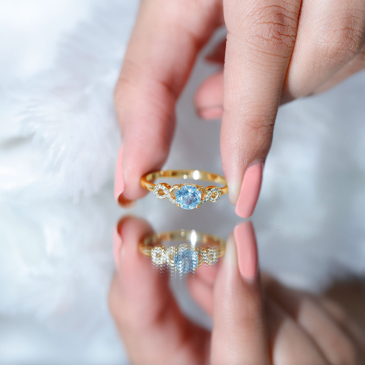 Round aquamarine and diamond infinity engagement ring by Rosec Jewels featuring a sleek band and sparkling gemstones.