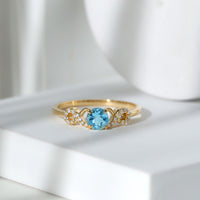 Round aquamarine and diamond infinity engagement ring by Rosec Jewels, featuring a sleek round shape and sparkling gemstones.