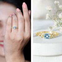 Round aquamarine and diamond infinity engagement ring by Rosec Jewels, featuring a sleek band with sparkling gemstones.