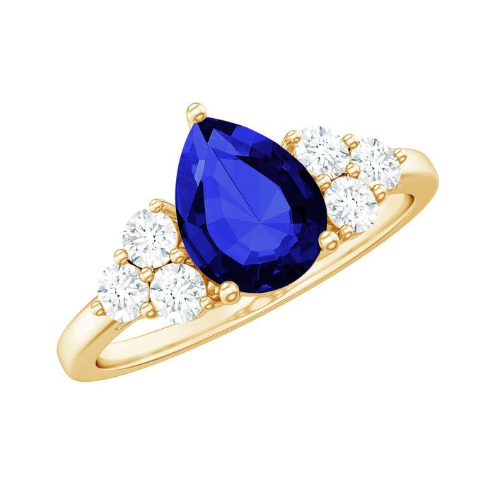 Lab grown blue sapphire pear engagement ring with diamond trio, crafted by Rosec Jewels, showcasing a 1.6 carat center stone and elegant design.