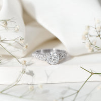 Vintage-style 2 carat moissanite engagement ring with double prong setting, featuring intricate detailing and rose gold finish.