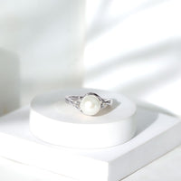 Natural 7.4 carat freshwater pearl engagement ring with diamond trio set in a Rosec Jewels ring, featuring elegant craftsmanship.